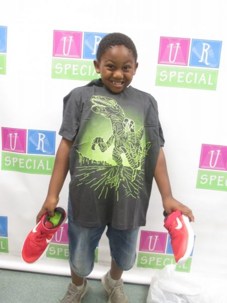 A boy shows off his shirt and shoes