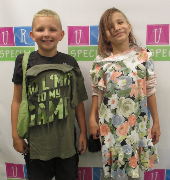 Two kids show off their clothes